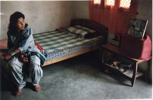 Muslim woman at home, sitting on a bed, South Asia or Middle East, photograph by Jean Shifrin, 1992.