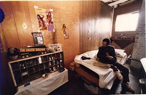 Homeless man, Joe, sitting on his bed in a room in the vacant MARTA bus repair facility on Piedmont and Pine, now demolished, Atlanta, Georgia, August 23, 1992.