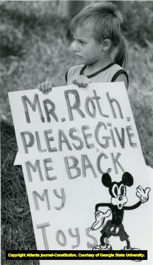 Anton Chelnokov holding a sign in front of the R.A. Roth moving company's offices in Tucker, Georgia, August 7, 1990. The child is protesting the confication of circus equipment by Roth for non-payment of bills.