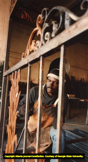 Carnell Robinson working on a metal bed headboard, Candler Warehouse, Atlanta, Georgia, October 13, 1993.