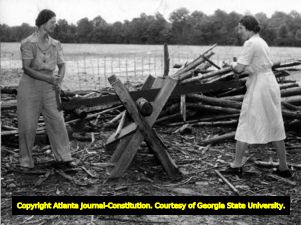 Catherine (left) and Rachel Meldrim cutting stove wood, possible in Meldrim (outside of Savannah), Georgia, July 6, 1944.