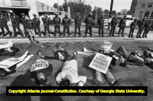 Police stand in front of the Centers for Disease Control as gay activists from ACT UP stage a 'die-in' to protest the CDC's handling of the AIDS crisis, Atlanta, Georgia, January 9, 1990.