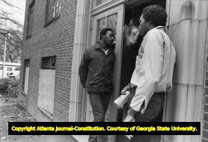 Two African American men standing in the doorway of a derelict apartment (?) building, Atlanta, Georgia, February 17, 1982.