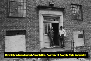 Two African American men standing in the doorway of a derelict apartment (?) building, Atlanta, Georgia, February 17, 1982.