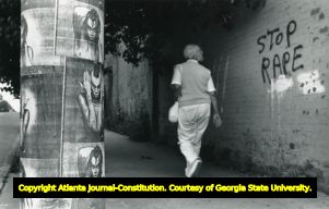 Woman walking through midtown underpass, graffitti says "Stop Rape," Atlanta, Georgia, June 28, 1987.