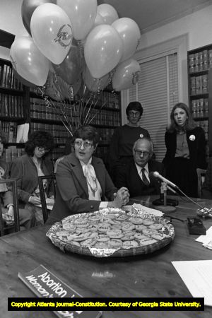 Lawyer Margie Pitts Hames and Dr. Newton Long, seated at table, on the anniversary of Doe v Bolton, Atlanta, Georgia, January 22, 1982. Lynne Randall standing behind Dr. Long.