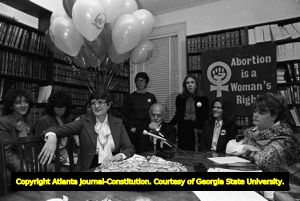 Margie Pitts Hames, Dr. Newton Long, Denise McLaughlin, and Kay Scott (left to right, seated at table) at press conference on anniversary of Doe v Bolton, Atlanta, Georgia, January 22, 1982. Lynne Randall is standing behind Dr. Long.