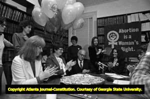 Ann Rose, Margie Pitts Hames, Dr. Newton Long, Denise McLaughlin, and Kay Scott (left to right, seated at table) at press conference on anniversary of Doe v Bolton, Atlanta, Georgia, January 22, 1982. Lynne Randall is standing behind Dr. Long.