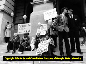 Female students at pro-Equal Rights Amendment demonstration in front of State House, while two young suited males look on, Atlanta, Georgia, 1980s.