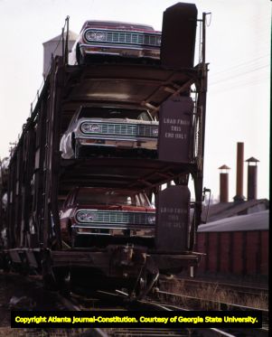 Automobiles traveling by freight train, Atlanta, Georgia, December 10, 1963.