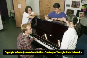 Students gathered around a piano, rehearsing for "Peep Show," a live performance put on by Georgia Tech to promote AIDS awareness, Atlanta, Georgia, December 27, 1993.
