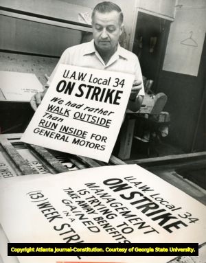 Edward J. Moore, displays two United Auto Workers picket signs, Atlanta, Georgia, September 1970.
