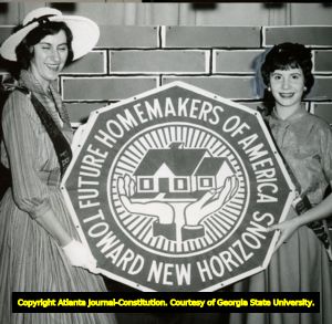 Two candidates for the State President of the Georgia Association of Future Homemakers of America hold their emblem. Carrollton, Georgia, April 13, 1958.