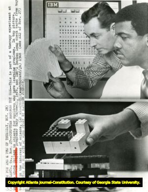 Gary Carswell and Herman Long check the computer's punch cards for test results in a therapy experiment for children with learning disabilities, Georgia State College, Atlanta, Georgia, November 27, 1968.