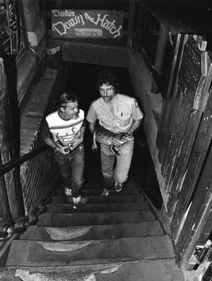 Restaurant owner, Dante Stephenson, and Zoo Atlanta employee, Kent Benedict, transporting a small crocodile by hand from Dante's Down the Hatch, in Underground Atlanta, Atlanta, Georgia, July 25, 1981.