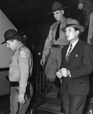 Convicted murderer, Richard "Dapper Dick" Gallogly, being escorted by two policemen following his capture, Georgia, March 25, 1940.
