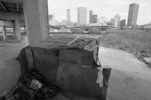 Homeless living area behind the Omni Coliseum; downtown skyscrapers in distance, Atlanta, Georgia, August 3, 1988.