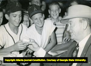 Ty Cobb, baseball great, autographs a ball for young fans, 1950s