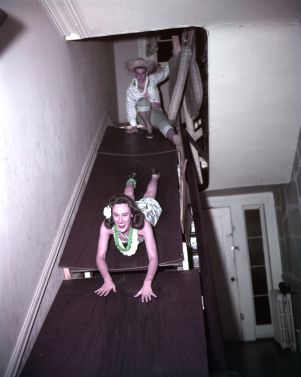 Sliding down the stairs at Pi Kappa Alpha's costume party, Athens, Georgia, January 22, 1957.