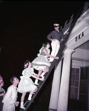 Climbing to the roof during a Pi Kappa Alpha costume party, Athens, Georgia, January 22, 1957.