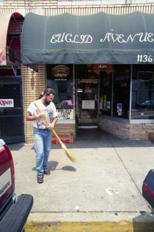 Euclid Avenue Yacht Club bar owner, Don Hinamon, sweeping the sidewalk infront of his bar, Little Five Points, Atlanta, Georgia, June 22, 1991.