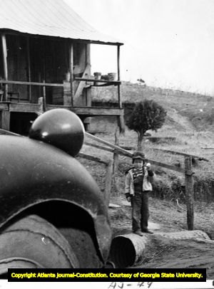Waiting for the Rolling Store, a little boy hopes to trade an egg for jawbreakers, Georgia, ca. 1930s, 1940s.
