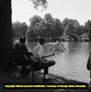 Caucasian men watching African Americans swimming in the newly integrated Lake Clara Meer, Piedmont Park, Atlanta, Georgia, June 12, 1963.