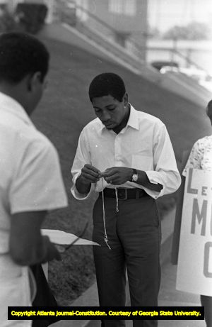 African American protestor prparing to picket outside of the Atlanta Public Schools building, Atlanta, Georgia, September 19, 1967.