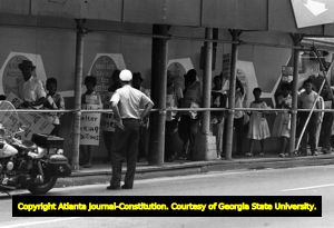 Atlanta Police officer watching a peaceful civil rights march, Forsyth Street, Atlanta, Georgia, July 1963.