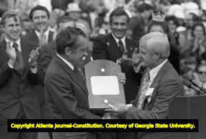 President Richard Nixon receives a plaque from Gerald A. Ludick, President of the Madison County Sertoma Club, at an Honor America Day Ceremony, Huntsville, Alabama, February 18, 1974.
