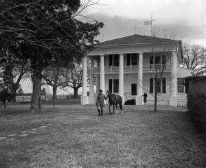 Colonel William O. Poindexter and his wife in front of their mansion, Rebel House (formerly the Rutlidge Home plantation), LaGrange, Georgia, January 27, 1959.