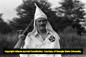 Ku Klux Klan member, J.W. Rogers, carrying a shotgun and cigarette, at a KKK rally in Buchanan, Georgia, June 20, 1981.
