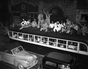 Soldiers and others celebrate V-J Day ("Victory over Japan Day") on top of a streetcar on Peachtree Street, Atlanta, Georgia, August 14, 1945.