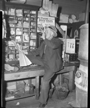 Reading the newspaper and enjoying a coke at the general store, Young Harris, Georgia, January 1947.