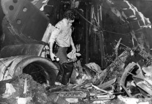 Rescue worker combing through the wreckage of a plane crash, New Hope, Georgia, April 5, 1977.