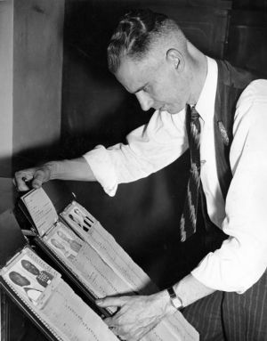 Police captain checking fingerprints in the morgue, Atlanta, Georgia, October 1940.