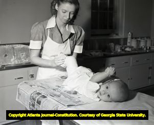 Nurse putting a cast on an infant with polio, circa 1940s