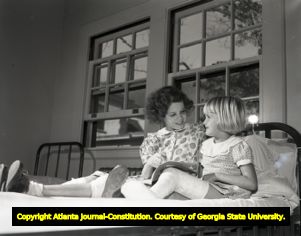 Young girls with polio reading to one another, circa 1940s