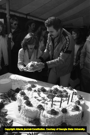 Burt Reynolds and Sally Field distribute pieces of Reynold's birthday cake, 1980