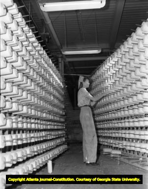 Woman industrial worker prepares spools for the asbestos fabric loom, 1947