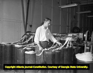 Asbestos fibers are strung into containers by worker, 1947
