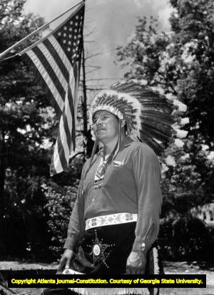 Cherokee Indian chief, wearing full headdress and costume. Shown with American flag, Rossville, Georgia, 1968