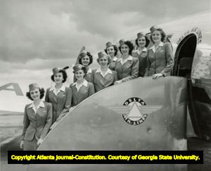 Nine flight attendents pose while exiting a Delta Air Lines plane, 1940s?