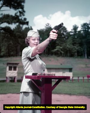 Major Katherine Sutherland practices her shooting skills at the gun range, 1958