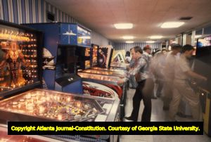 Arcade of pinball machines and video games being played, 1980