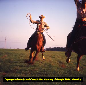 Ronnie Hodges and Tommy Breedlove race by on top of their quarter horses, 1965