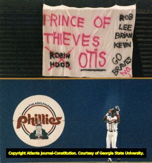 Braves Otis Nixon catches a ball under a fan made sign in his support, 1991