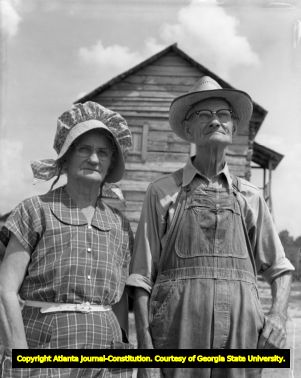 Farmer and wife pose in front of New Echota building, 1960