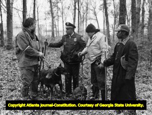 Volunteers and police discuss evidence found after searching a crime scene, 1981