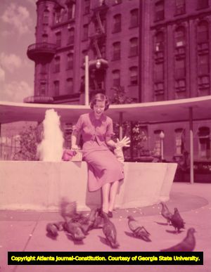 Woman feeding birds within Plaza Park, circa 1940s